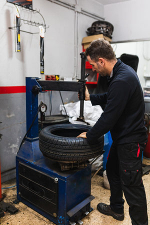 Mechanic changing the rubber of a wheel. Automobile mechanics concept