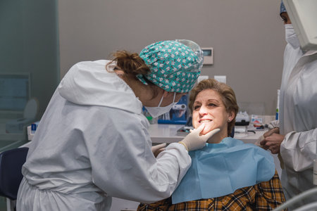 woman dentist in dental office talking with female patient and preparing for treatment.
