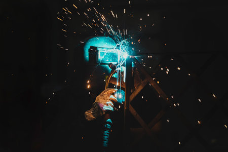 Welder welding with welding machine. Metalwork manufacturing and construction maintenance service by...