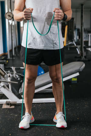 unrecognizable man performing elastic band exercises.の写真素材