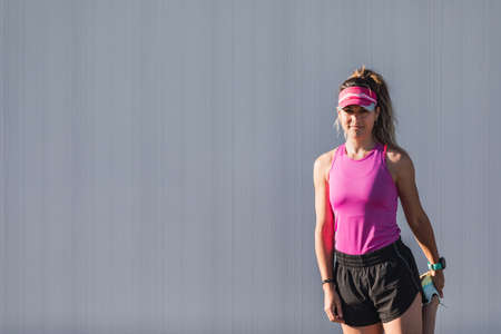 Woman stretching her legs before a run on a city street. Preparation for running workoutの写真素材