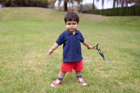 Child playing with a slingshot in the street.の写真素材