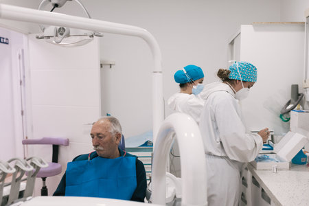 Patient waiting in the dental clinic, two nurses preparing for the procedure.の写真素材