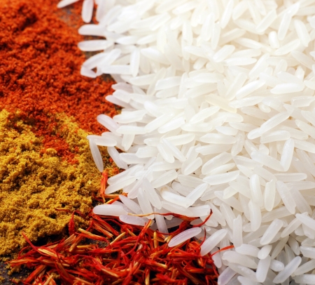 White rice and indian spices(curry and saffron) background. square image, selective focusの写真素材