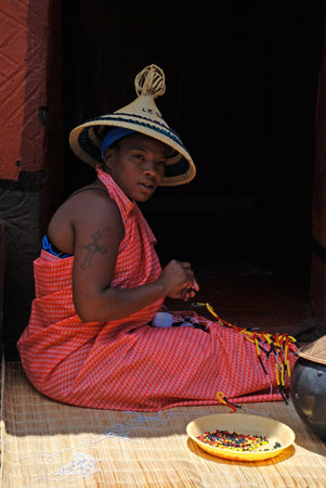 LESEDI CULTURAL VILLAGE, SOUTH AFRICA - JAN 1  Sotho woman wearing handmade clothing and conical hat...
