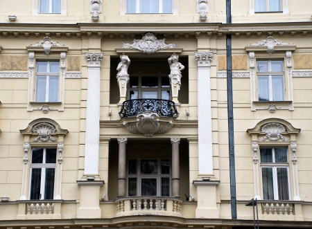 Ornate facade palace in baroque style with balkony and sculptures (Prague, Czech Republic).のeditorial素材