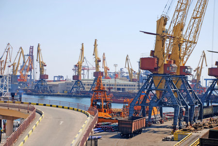 A cargo container ships and cranes is docked at the shipyard.