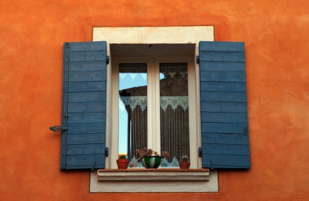 old french open window with blue shutters in red rural house, Provence, France  の写真素材