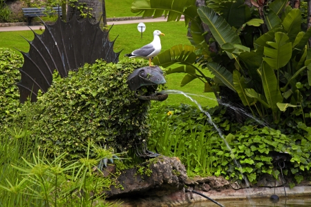 Ornamental green garden with iron pangolin sculpture fountain(Monte Carlo)の写真素材
