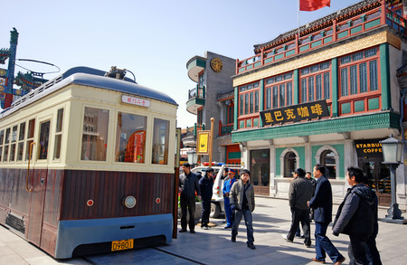 BEIJING, CHINA - MARCH 25: Tourists, local people and traditional tram on Qianmen Street on March 25,2010 in Beijing, China.のeditorial素材