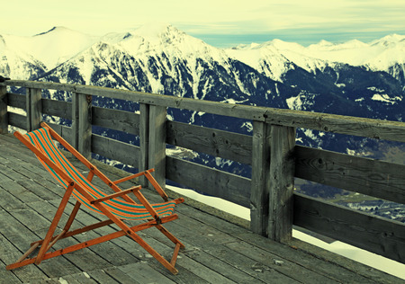 lounge chair on wooden terrace at mountain ski resort in Alps, Austriaの写真素材
