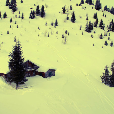 Snow Covered Alps Mountain and small houses in winter day (Austria).