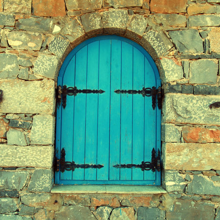 Vintage window with blue close shutters in old stone wall, Crete, Greece.   の写真素材