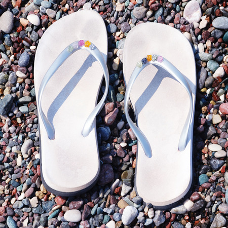 flip-flops on a pebble beach backgroundの写真素材