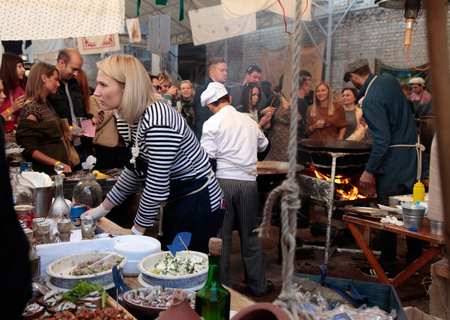 KYIV, UKRAINE - OCTOBER 11, 2014: Unidentified people cook and trades traditional dishes of Odessa restaurant on food stall in Street Food Festival in Kyiv, Ukraine.のeditorial素材
