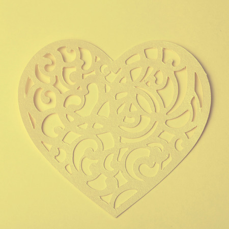Valentine carving heart cutted from paper on the paper background, vintage toned imageの写真素材