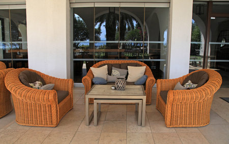 Beautiful patio with comfort rattan sofa, armchairs and pillows at summer resortの写真素材