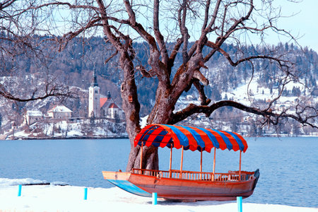 Beautiful winter landscape with traditional Slovenian boat and church on Lake Bled, Sloveniaの写真素材
