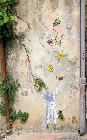 NICE, FRANCE - MAY 14, 2013: The artists paint some nice graffities on the vintage wall in Old Town of Nice, France.のeditorial素材
