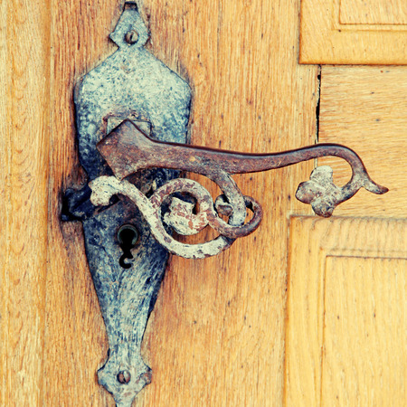 Old rusty iron handle in medieval door, square toned image,  selective focusの写真素材