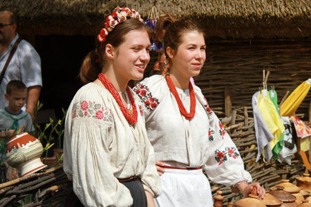 KIEV UKRAINE  JUNE 21 2015: Two young beautiful girls in Ukrainian blouses in outdoor ethnic village...