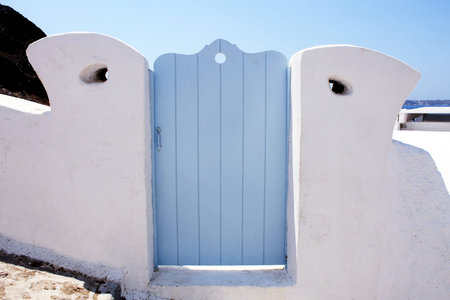 blue wooden gates in white house, beautiful details of Santorini island, Greece