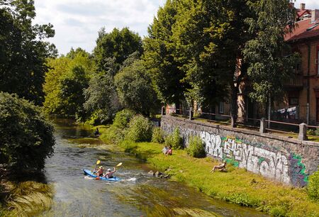 VILNIUS, LITHUANIA - JULY 19, 2015: People and canoe boat in River Vilnele near Uzupis neighborhood, Vilnius, Lithuania.のeditorial素材