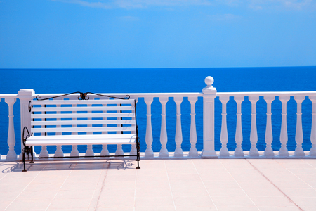 Summer view with classic white balustrade, bench and empty terrace overlooking the sea, selective focusの写真素材