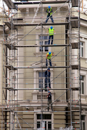 VILNIUS, LITHUANIA - JULY 20, 2015 : Team work at construction site, workers passing metal formworks...