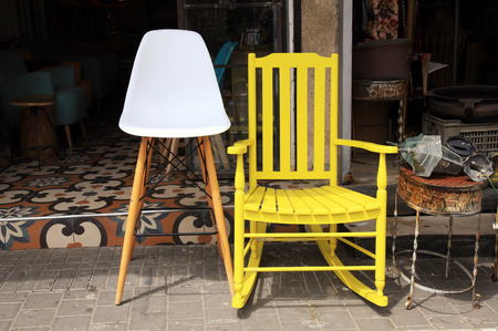 Vintage yellow rocking chair and lamp on street flea marketの写真素材