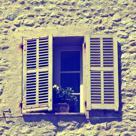 french rustic window with old wood shutters in stone rural house, Provence, France. square toned imageの写真素材