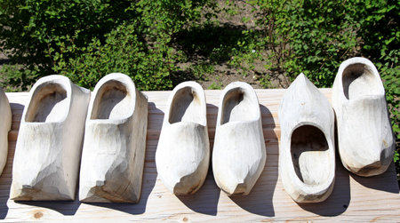 Dutch wooden shoes on a wood background. Pair of traditional clogs made of wood. Klompen,...