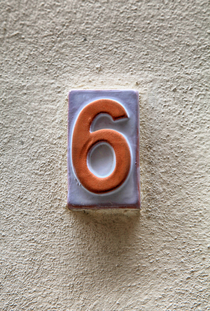 Weathered house number six(6) on a old plaster wallの写真素材