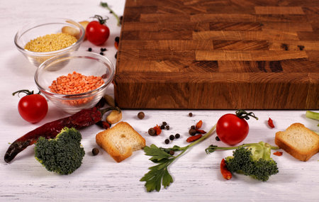 Organic food with empty brown cutting board on white wooden table. Organic food for healthy...