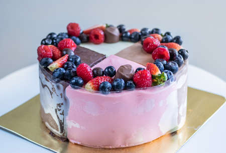 Mix Cakes with berries and chocolate candies on a golden backing. Picture for a menu or a confectionery catalog.の写真素材