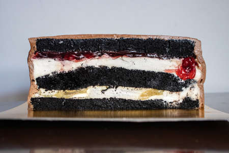 A half of chocolate cake with black glaze on a black table. Picture for a menu or a confectionery catalog.の写真素材