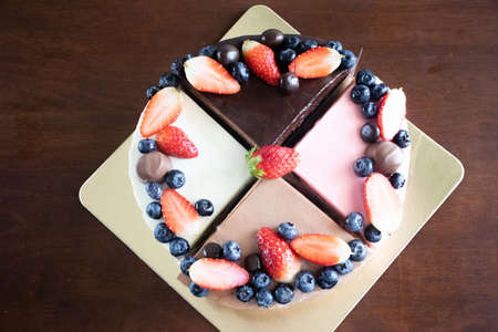 Mix Cakes with berries and chocolate candies on a golden backing. Picture for a menu or a confectionery catalog.の写真素材