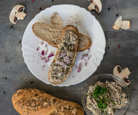 Fresh pastry with champignon spread on a gray background with whole colored pepper and pieces of mushroomsの写真素材