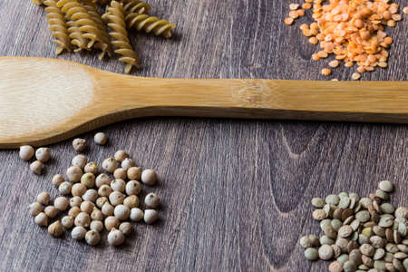 Vegetables. Decorations of ingredients of red and dark lentils, chickpeas and wholegrain pastaの写真素材
