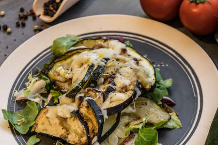 Baked zucchini and eggplant on ice salad sprinkled with cheeseの写真素材