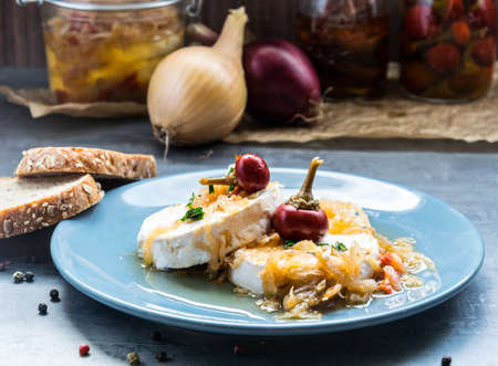 Cheese with white mold sprinkled with onions decorated with hot pepper. Delicious snackの写真素材