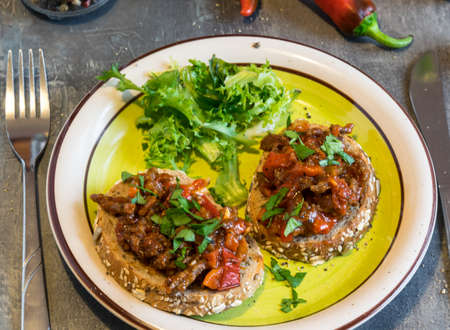 Beef meat with tomatoes and pepper on fried bread, herbaceous. Great dinnerの写真素材