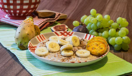 Delicious oatmeal with chocolate and pieces of fruit made of figs, bananas, grapes and cacti figsの写真素材