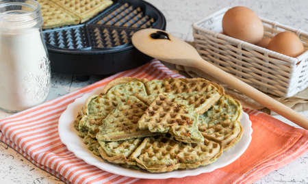 Home made waffles with spinach, heart shaped. Delicious breakfastの写真素材
