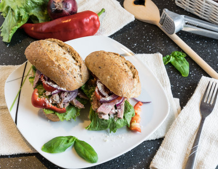 Homemade sandwich with pieces of grilled pork, vegetables and mayonnaise