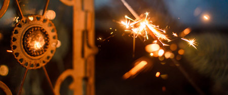 Sparkler for Christmas on the background of a beautiful lamp and in the New Years surroundings, the...
