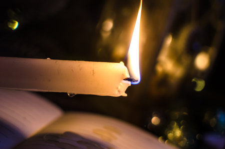 Lighted candle in a festive setting with Christmas decorations, cozy and atmospheric photoの写真素材