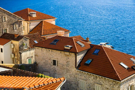 A trip to the tourist old town of the Adriatic coast Perast in Montenegro among the mountains and with beautiful old buildings with red tiles, there are many cafes in the city, narrow streets and clean air with seagulls and catsの写真素材