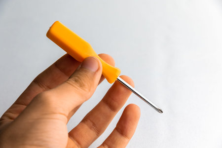 man of man that hold a screwdriver with handle rubber of red color on the white background