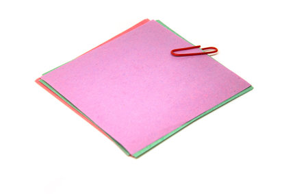 Red paper clip attached to multiple sheets of paper.